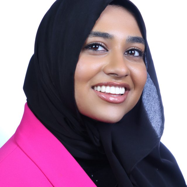 Headshot of Mariam Sayed in a hot pink blazer with a black hijab.