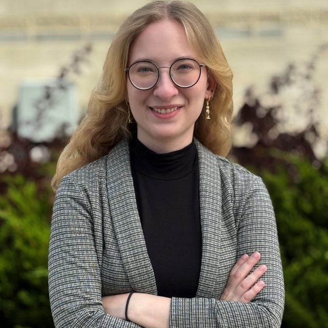 Image of Michigan State University student Kierra Jursch smiling in a grey blazer and black top, with arms crossed.