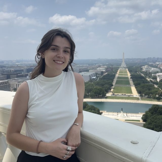 Abigail Livingston is smiling at the camera and the background shows a view of the Washington Monument in Washington, D.C.